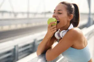 Eine Frau beißt nach dem Sport in einen Apfel